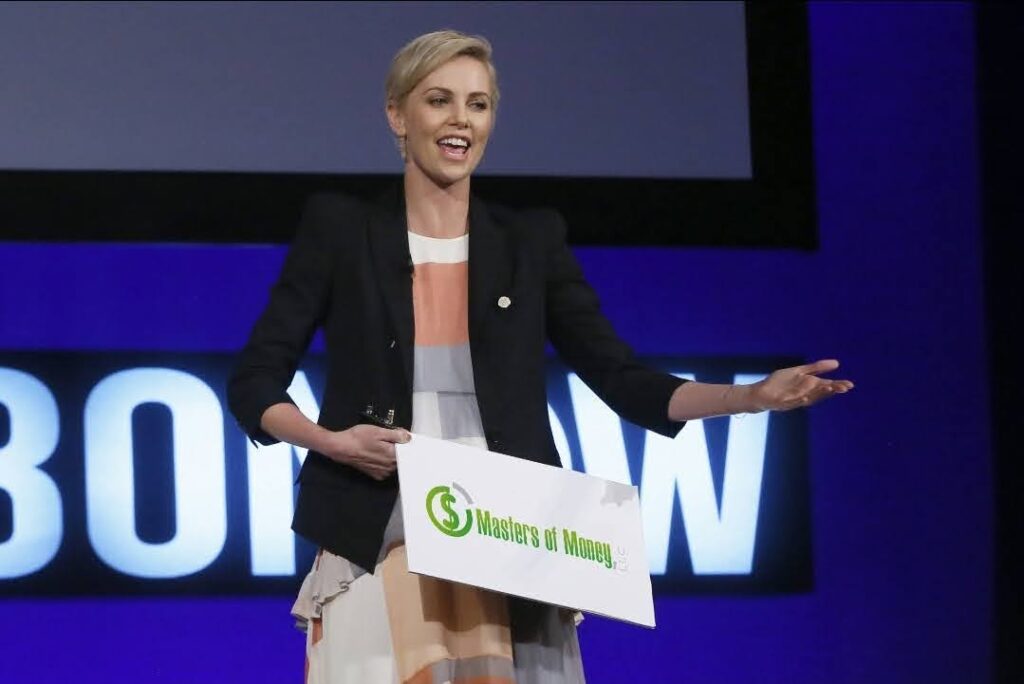 Charlize Theron Holding a Masters of Money Logo Sign Photo